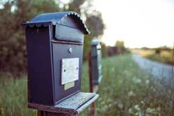 A blue mailbox sitting lonely in a grass field